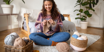 mulher feliz fazendo a decoração com crochê.