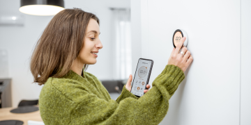 Mulher conferindo os sensores para automatizar casa e configurando uso.