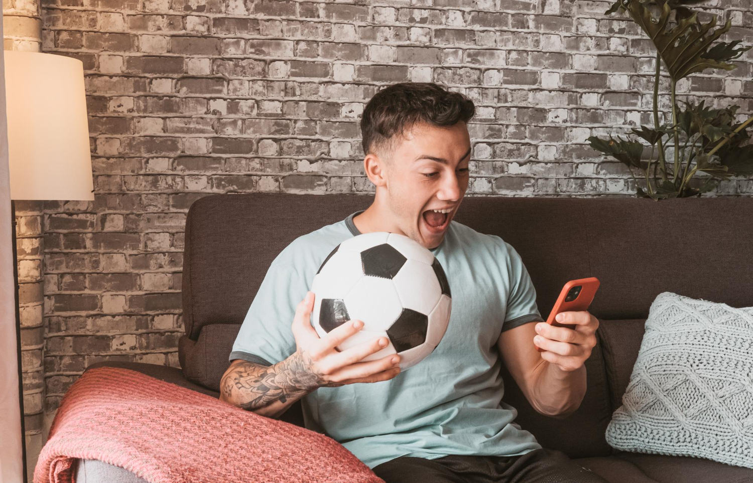 Homem feliz ao descobrir apps para assistir futebol de graça.