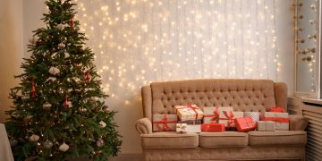 Sala de estar com o O que não pode faltar na decoração de Natal, usando luzes e árvore.