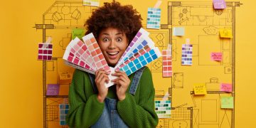 Mulher feliz ao descobrir como usar estampas e cores vibrantes na decoração, segurando paleta de cores.