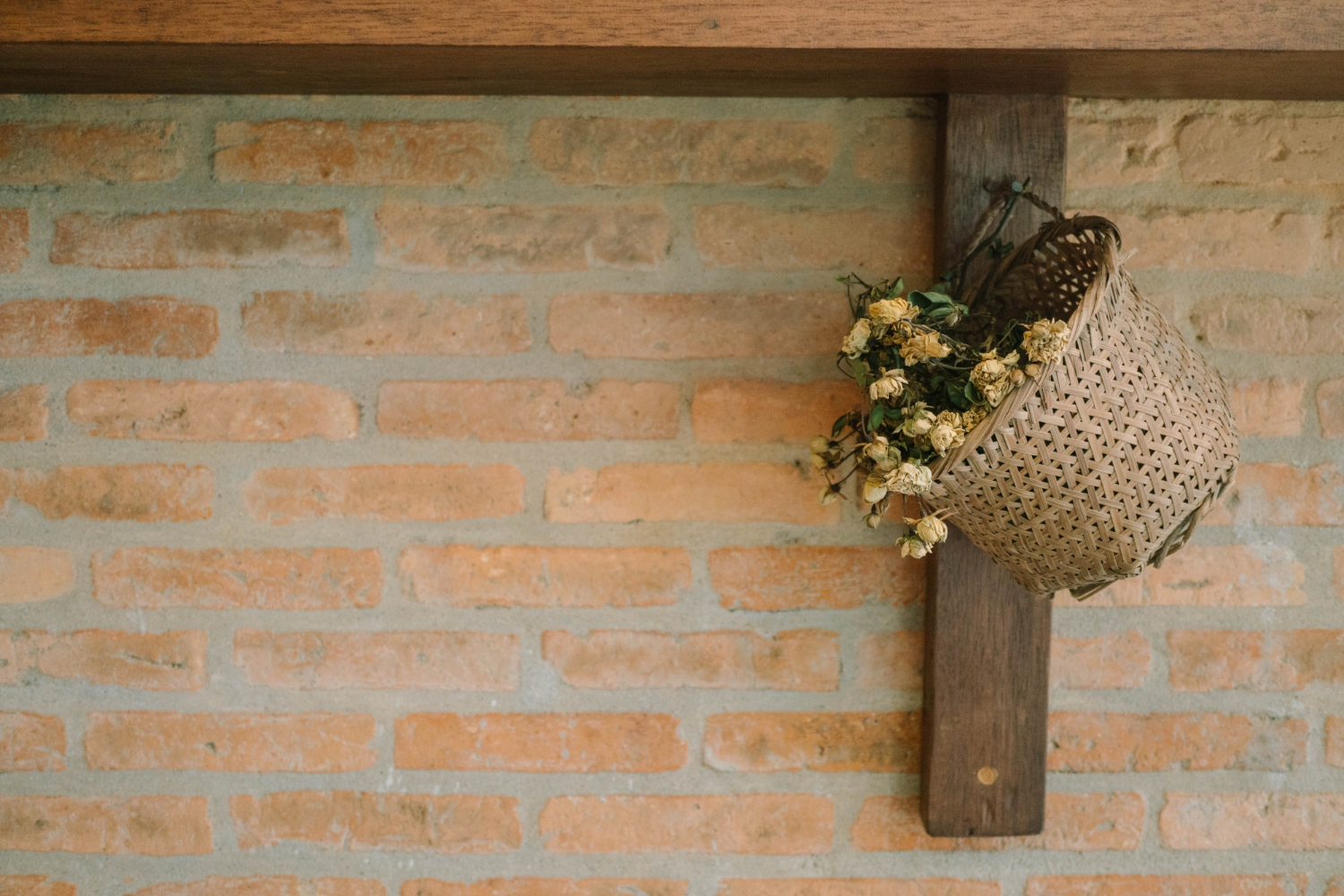 decoração rústica com tijolos na parede e flores penduradas