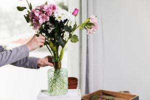 pessoa fazendo um arranjo com a Decoração com flores naturais.