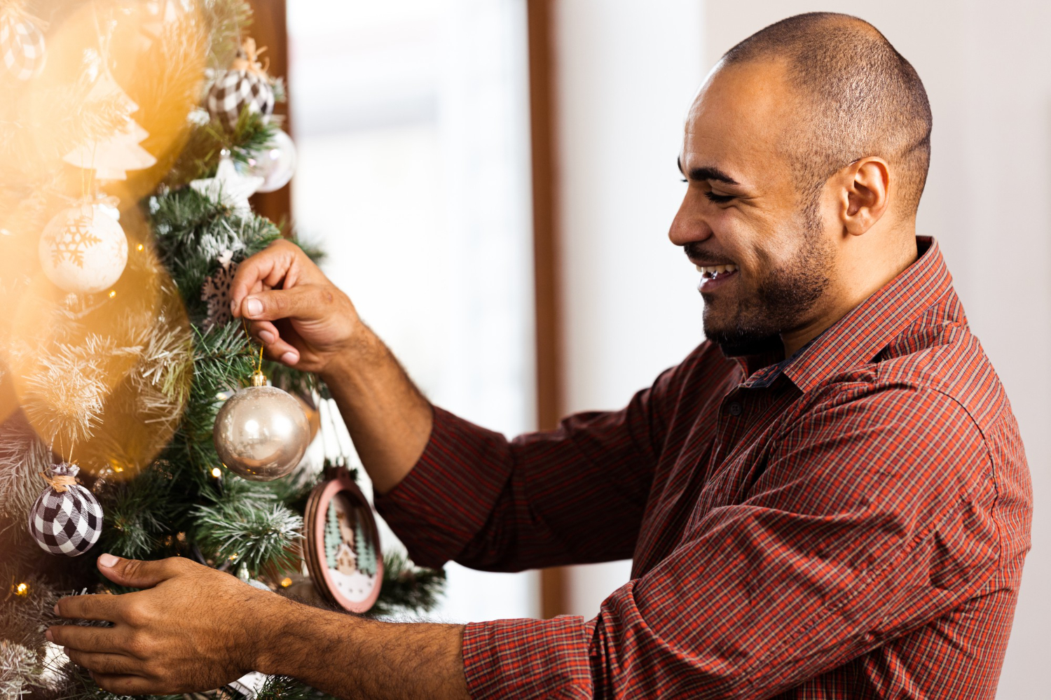 Homem montando Árvores de Natal diferentes.