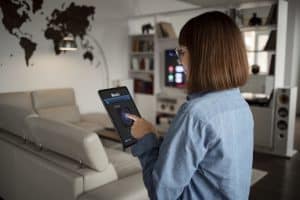 Mulher usando tablet com tecnologia integrada na casa