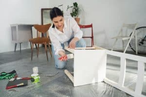Mulher aproveitando dicas de renovação de móveis com técnicas DIY.