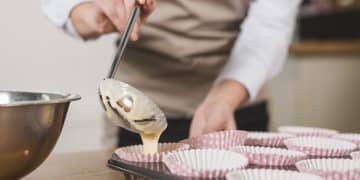close-up-female-baker-pouring-mixed-cake-batter-cupcake-holder